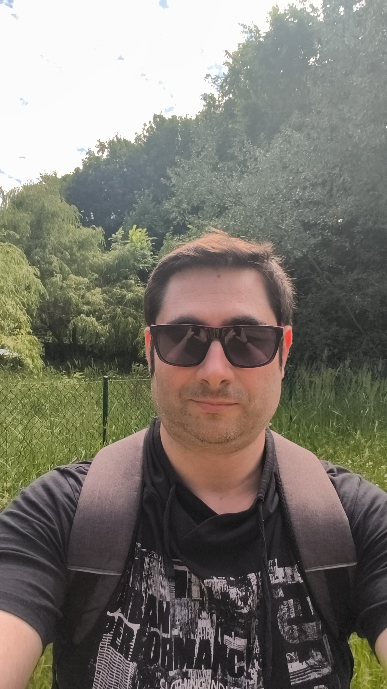 Between destinations — sunglasses, green canopy, a moment of observation